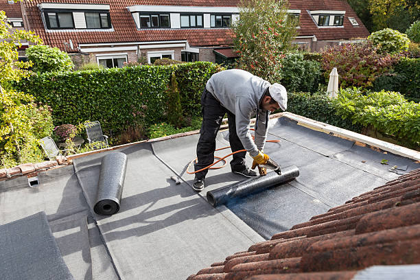 Roofer burning asphalt felts on the garage roof - for more click here